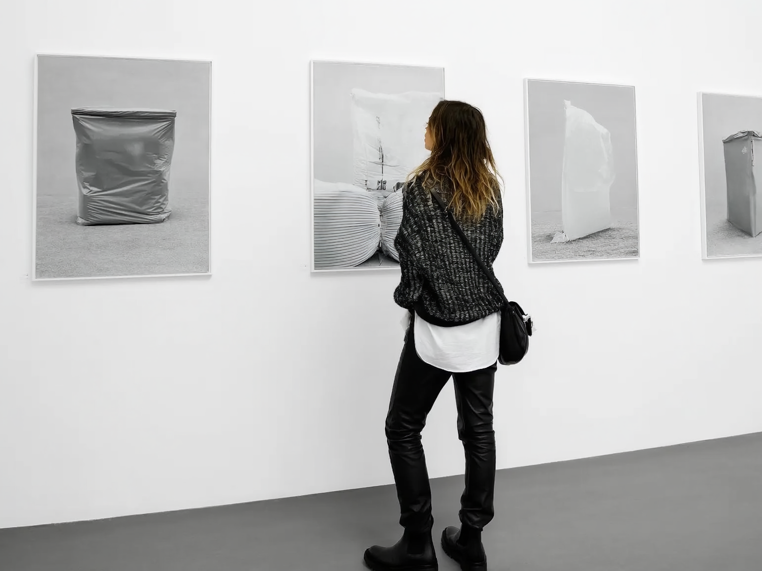 A visitor standing in front of large monochrome photographs in a gallery